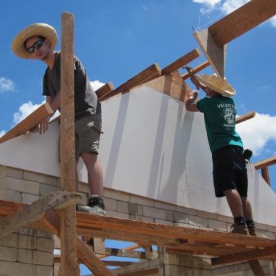 Projects Abroad teenage volunteers doing construction work in the Philippines work on a structure’s roof. Teenage volunteers doing building work in the Philippines work on a structure’s roof
